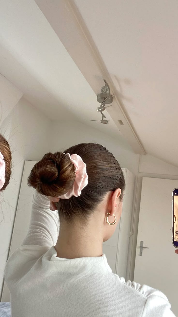 Roze zijden scrunchie in een strakke knot voor comfortabel en haarvriendelijk dragen